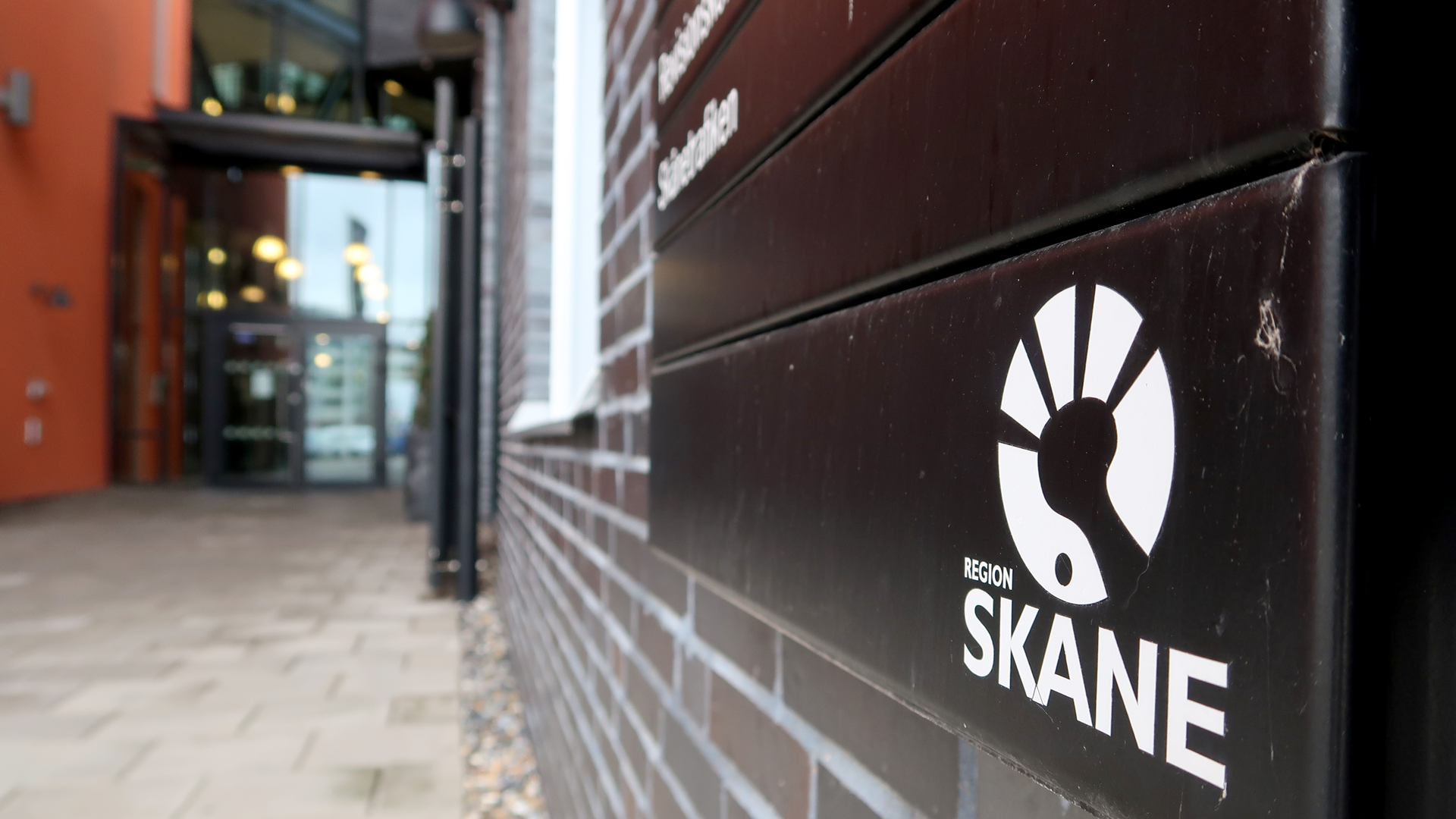 Skylt med Region Skånes logotyp utanför entrén vid Dockplatsen i Malmö.