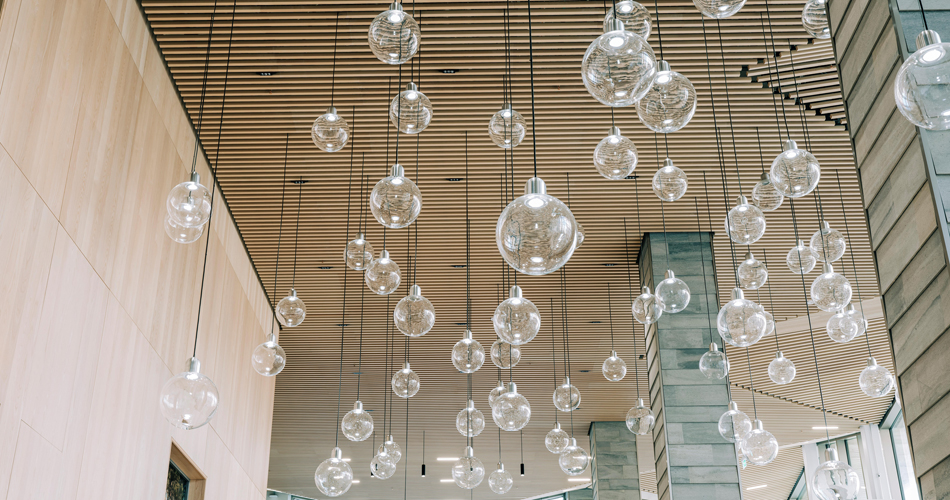 Flera glasglober hänger ner från ett träbeklätt inomhustak