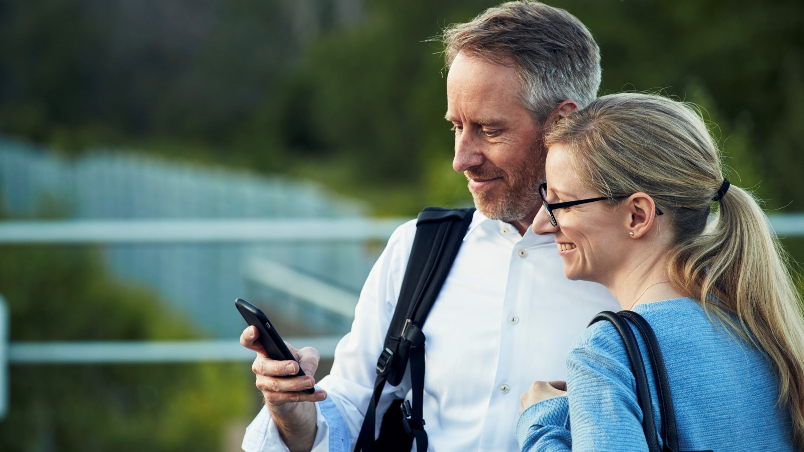 En man och en kvinna tittar på en mobil.