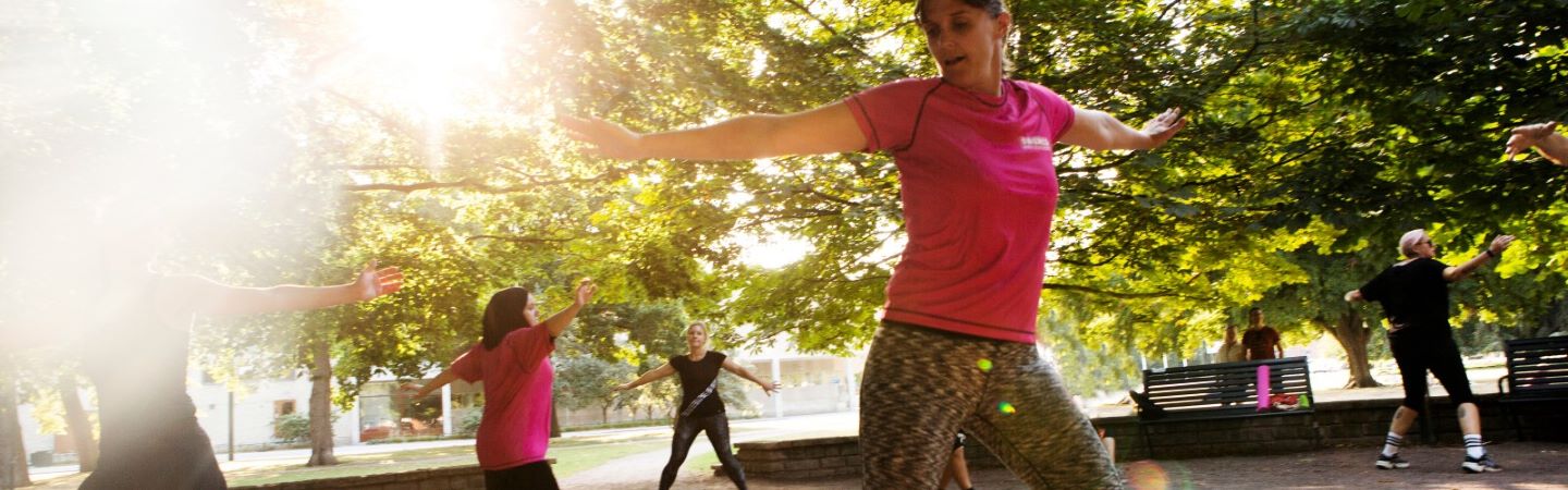 En grupp personer har ett träningspass utomhus i en park.